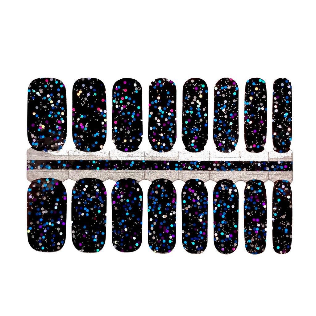 A close up of Galactic Glitter nail wraps on a white background. The wraps feature a black base with a multicolored glitter that will remind you of the night sky. The wraps are made of high-quality materials and are easy to apply and remove, making them a convenient choice for any manicure.