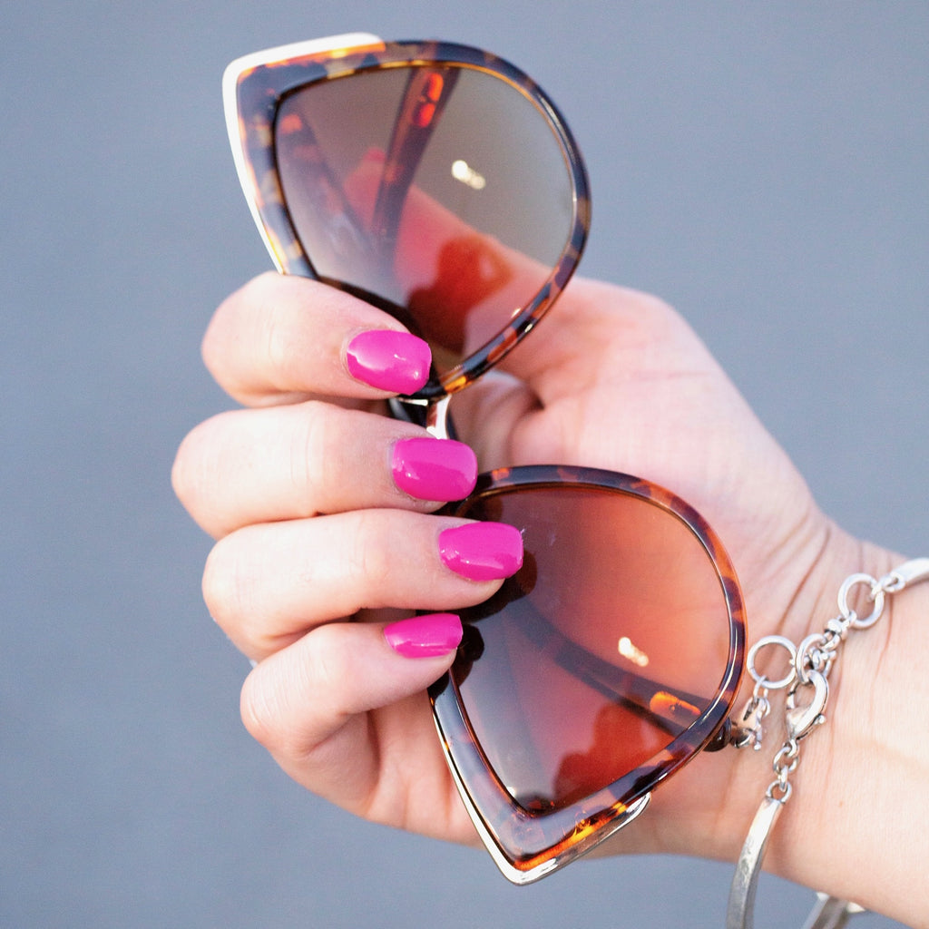 Model confidently displaying Hot Pink nail wraps on her perfectly manicured fingers, reflecting a bold and lively look. The vibrant hot pink color shines against her skin, exemplifying the elegance and charm of these DIY gel nail stickers - NailsMailed