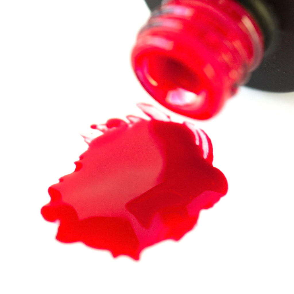 A bottle of Lady in Red shellac gel polish, showcasing its vibrant cherry red color with a high shine finish, positioned against a clean white background.