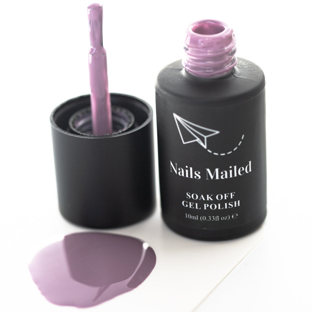 Close-up of a bottle of purple gel nail polish on a white background. The bottle has a black cap and the polish appears shiny and smooth.