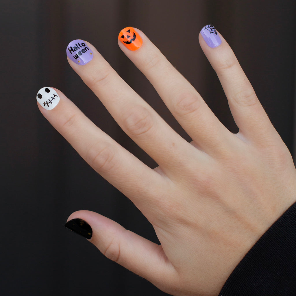 Spooky Spectacle gel nail wraps on a model's hand, featuring a variety of Halloween characters like Jack-o-lanterns, ghosts, and spiderwebs for festive, attention-grabbing nails.