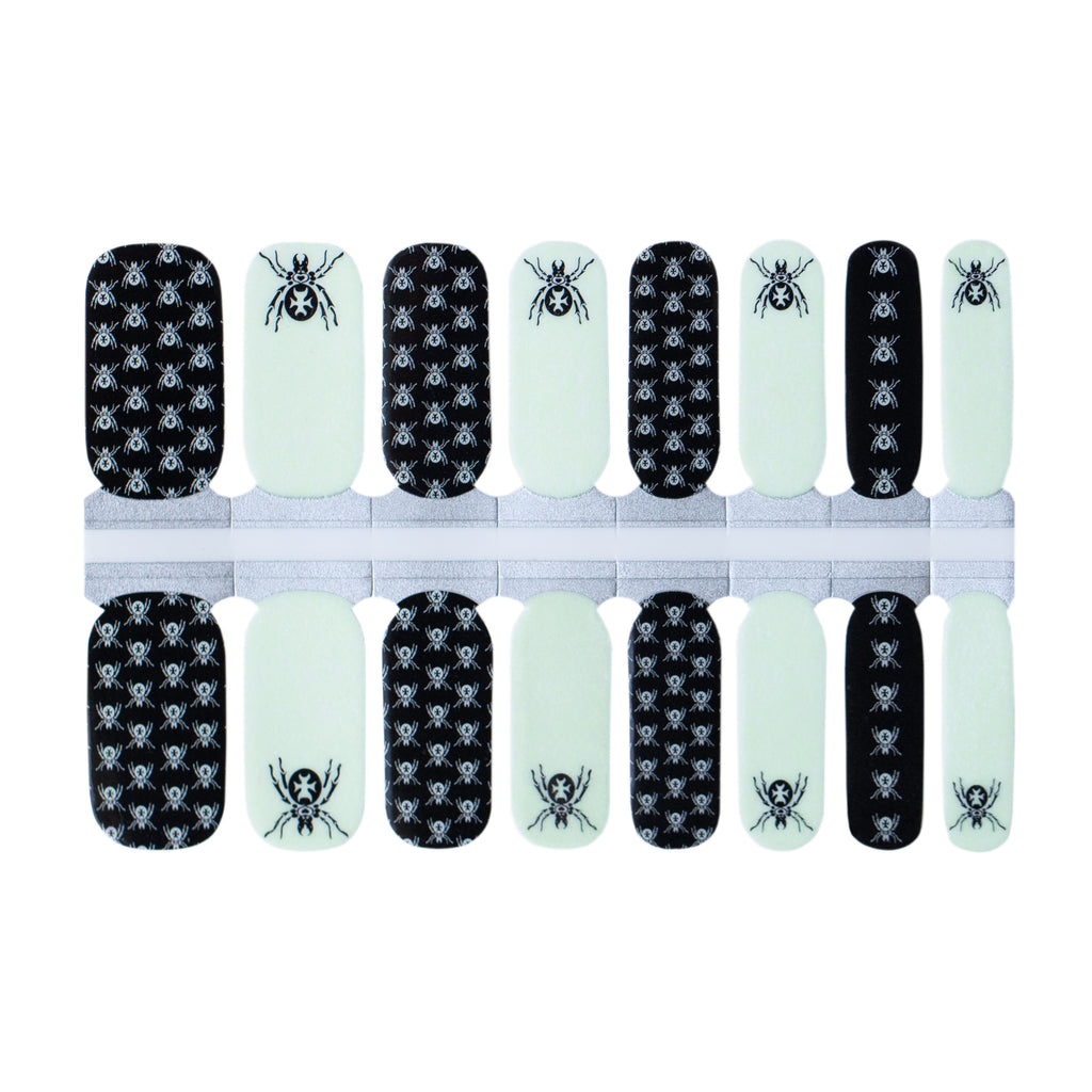Image of Glowing Spiders Classic Nail Wraps, featuring glow-in-the-dark white base with tiny black widows and accent nails in black showcasing a large black widow spider, ideal for achieving hauntingly beautiful Halloween nails.