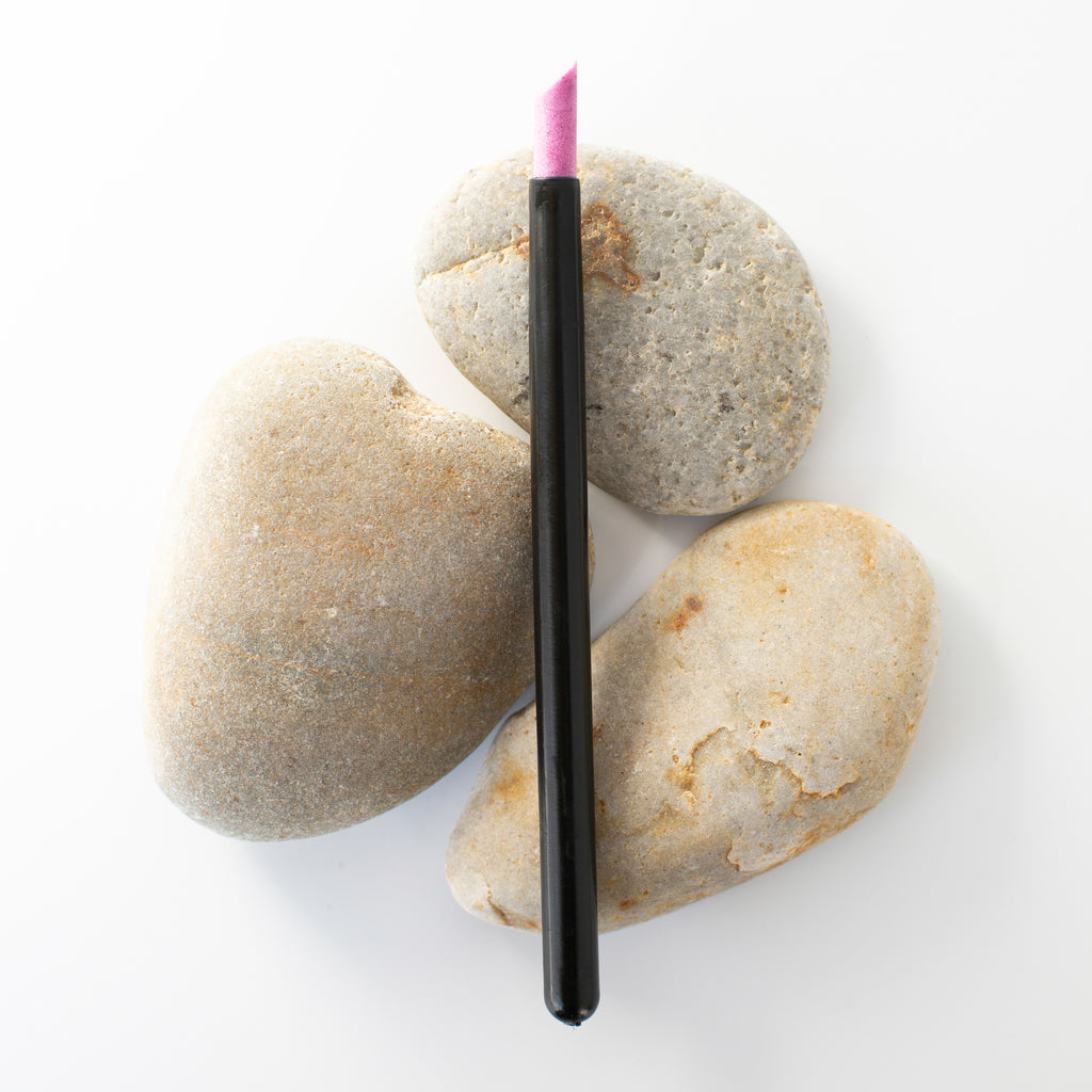 A high-quality cuticle pusher made of natural pumice stone, pictured on a plain white background. The tool features a rounded edge for pushing back cuticles and a rough surface for exfoliating nails. Its compact size makes it easy to hold and use, while its natural material ensures gentle and effective care for your nails.