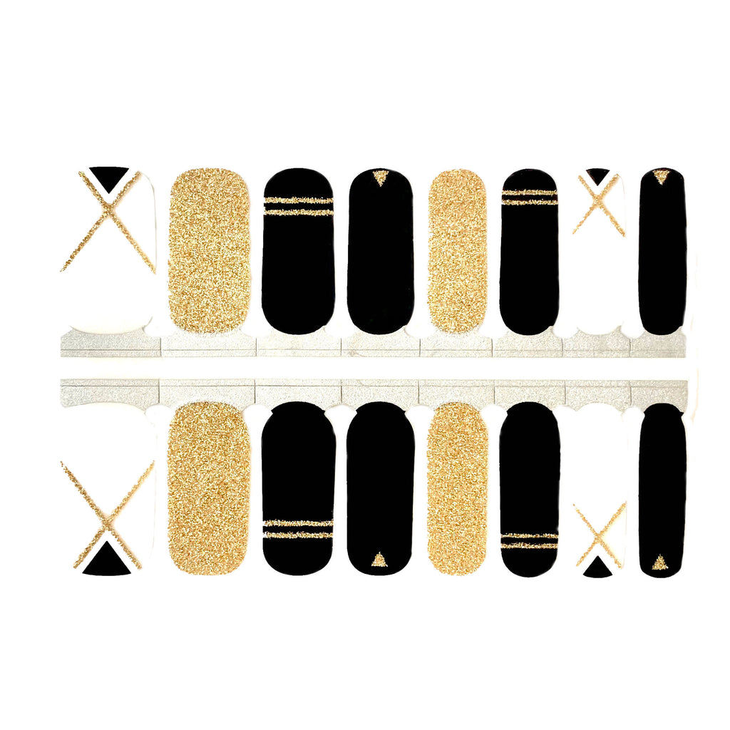 A close-up of a black nail wrap with gold glitter geometric shapes and negative space accent nail on a white background. The wraps feature a bold and eye-catching design and are made of high-quality materials. The wraps are easy to apply, making them a convenient choice for any manicure.