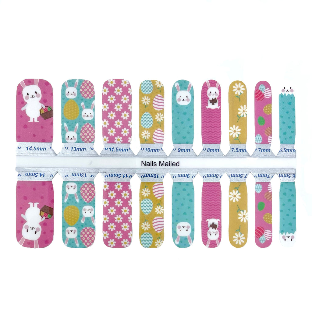 A close up of kids Easter bunny nail wraps on a white background. The wraps feature adorable Easter bunny designs and are made of high-quality materials. The wraps are easy to apply and remove, making them perfect for a child's manicure.