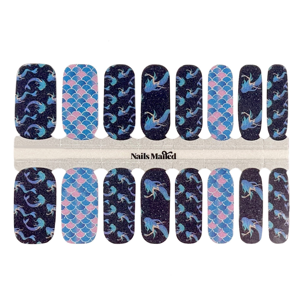 Dark blue and pink nail wraps with mermaid accent nails against a white background