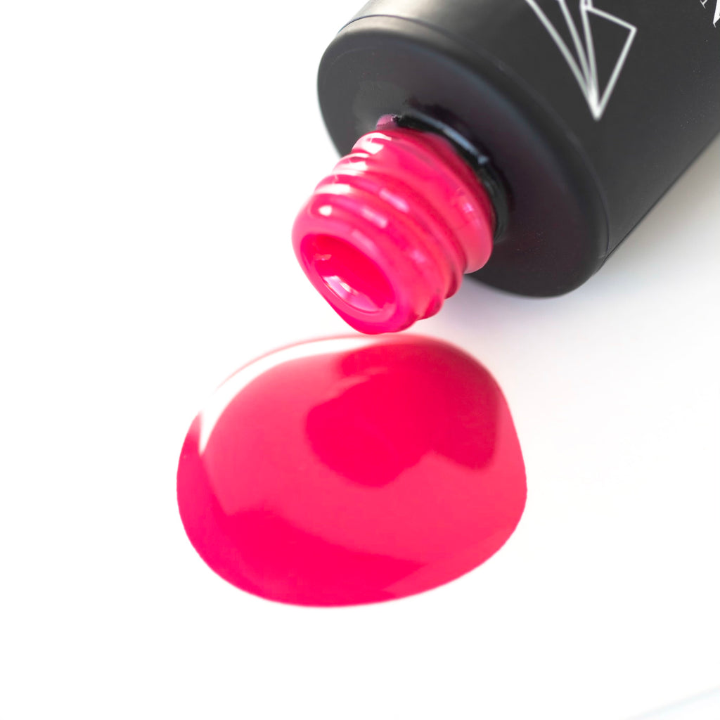 Lollipop gel nail polish, a bold and bright pink shade, is pictured against a white background. The round bottle has a black cap with a brush applicator sticking out of it. The light reflects off the glossy surface of the polish, highlighting the vibrant pink color. 