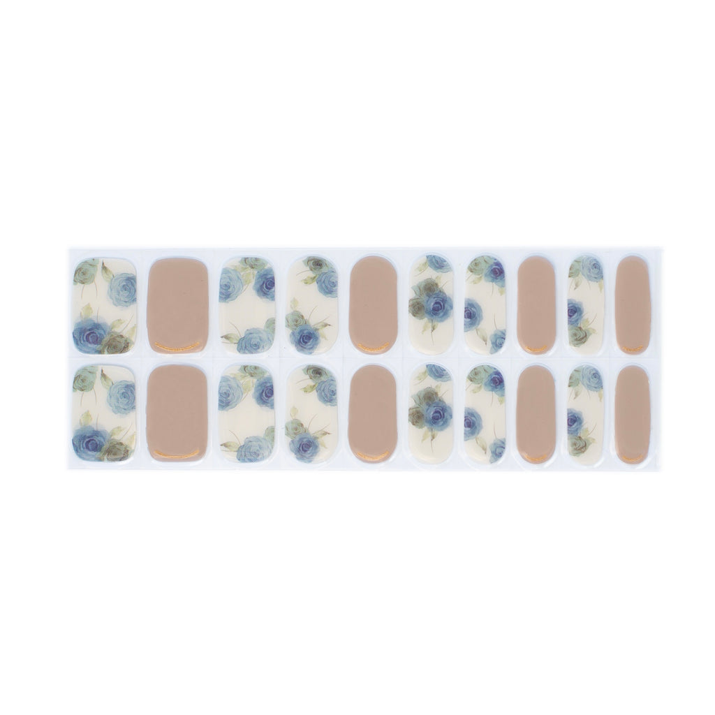A close-up image of Nails Mailed's "Blue Rose" Gel Nail Wraps, showcasing a harmonious blend of earthy tan base nails and vibrant accent nails adorned with intricate, blue roses. The wraps exude an aura of subtle sophistication, promising not just aesthetic appeal but also protection against nail damage.
