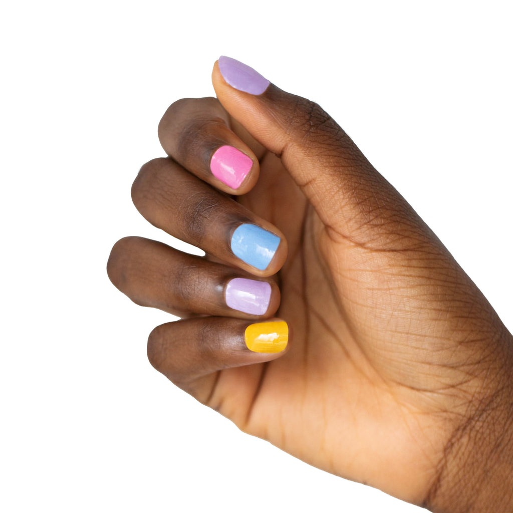 A model's hand adorned with Nails Mailed's "Perfectly Pastel" Gel Nail Wraps, showcasing a beautiful array of pastel hues, from gentle lilacs to soft pinks and dreamy blues. The pastel-colored nails illustrate the perfect blend of health-conscious nail care and DIY fashion.